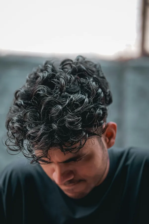 Curly fade haircut with short faded sides and textured curly top